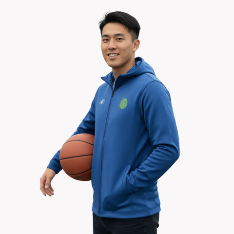 Young man smiling and holding a basketball, wearing a Royal Blue C2C Sport Glide SlimFit HP Tech zip hoodie with a green logo and hand in pocket